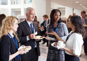 Attendees chatting and eating at a networking reception